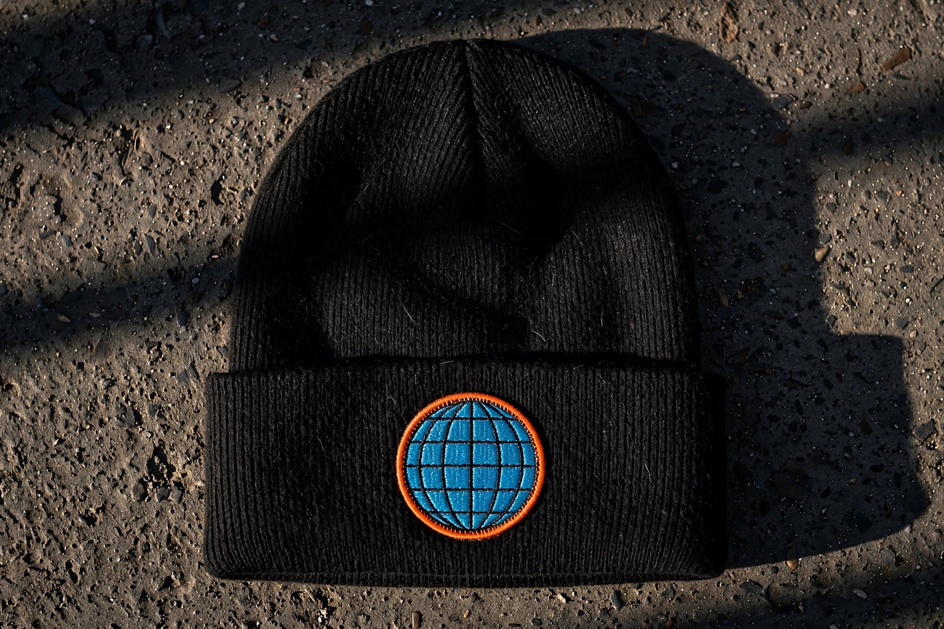 Black rib-knit beanie embroidered with the cyan and orange Globowrench globe logo