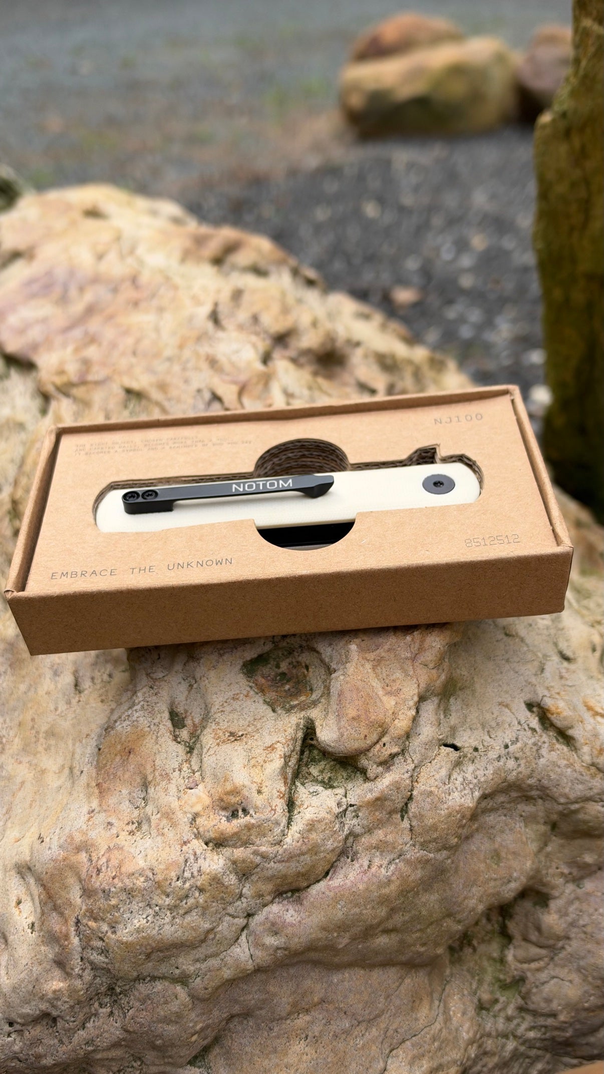 NOTOM NJ100 folding knife in its box on a rock
